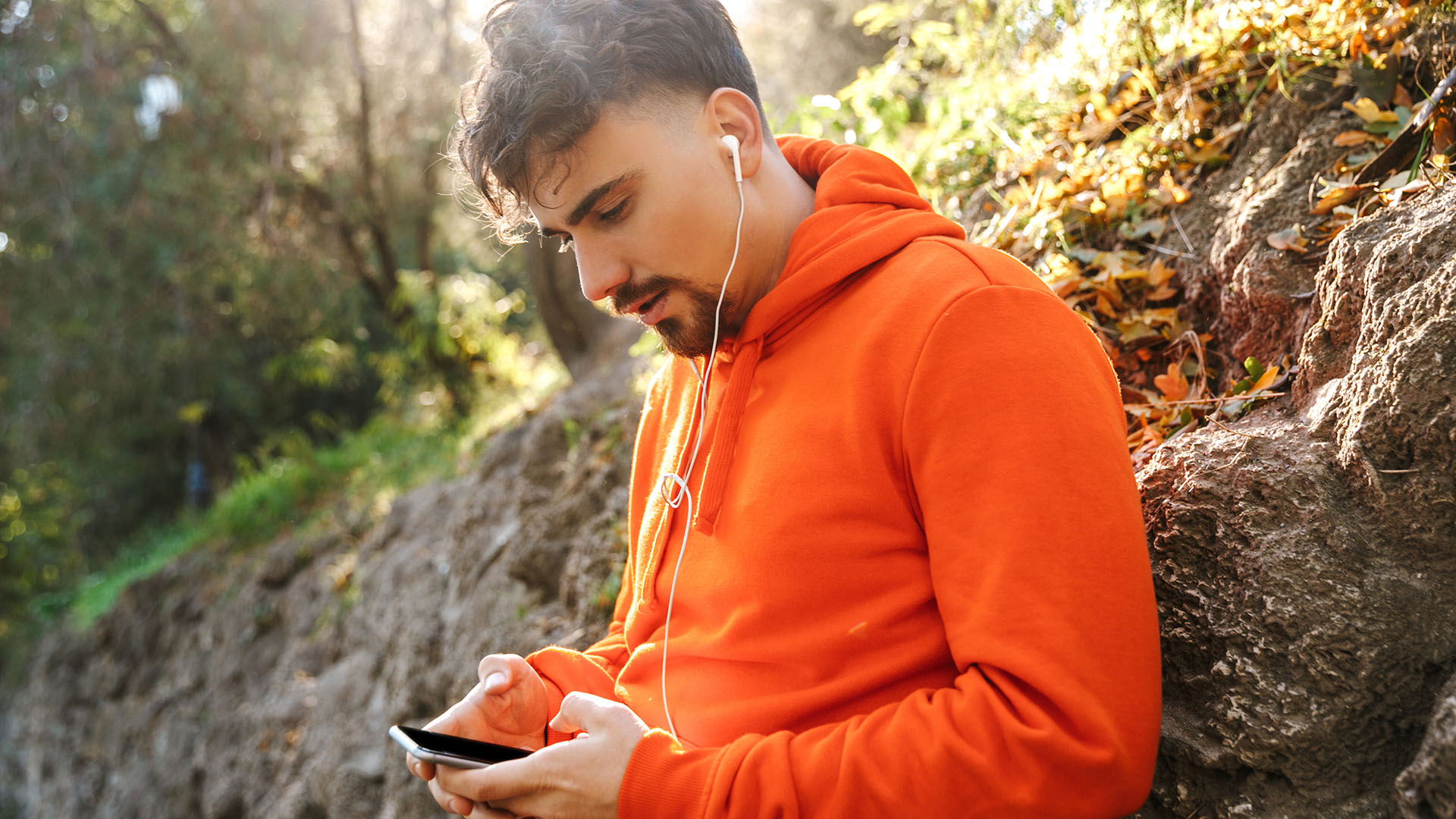 Man använder mobiltelefon utomhus
